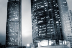 Skyscraper with traffic light and cars motion blurred in Hong Ko